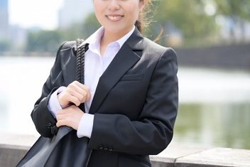 就活の面接会場へ向かうスーツ姿の女性とトートバッグの使用イメージ