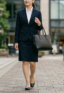 黒のトートバッグを持ちオフィス街を歩く就活生の女性の様子