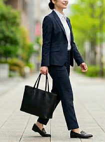 街中で、黒いトートバッグを持って、通勤している女性のイメージ