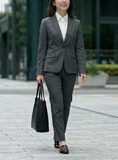 黒いトートバッグを持って通勤するスーツ姿の女性