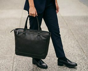 ファスナー付きの黒のトートバッグを持つ女性のイメージ