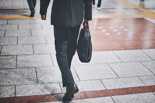 リクルートスーツを着てビジネスバッグを持ち、面接会場へ向かう就活生の歩き姿