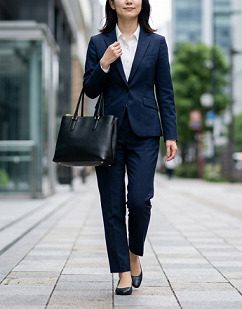 黒いトートバッグを持って街中を通勤する女性の様子