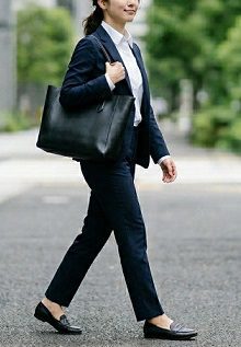 スーツで通勤する、黒いトートバッグを持った女性