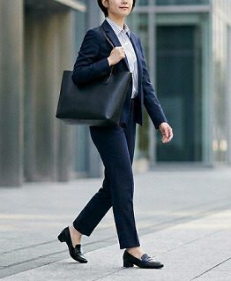 街中を、黒いトートバッグを持って、通勤する女性の様子
