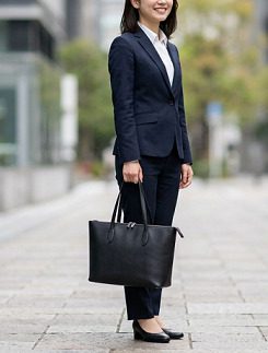 黒いトートバッグを持つスーツ姿の女性
