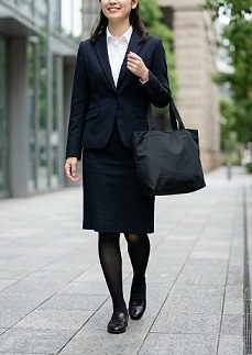 オフィス街で、黒いトートバッグを持って、通勤している女性の様子
